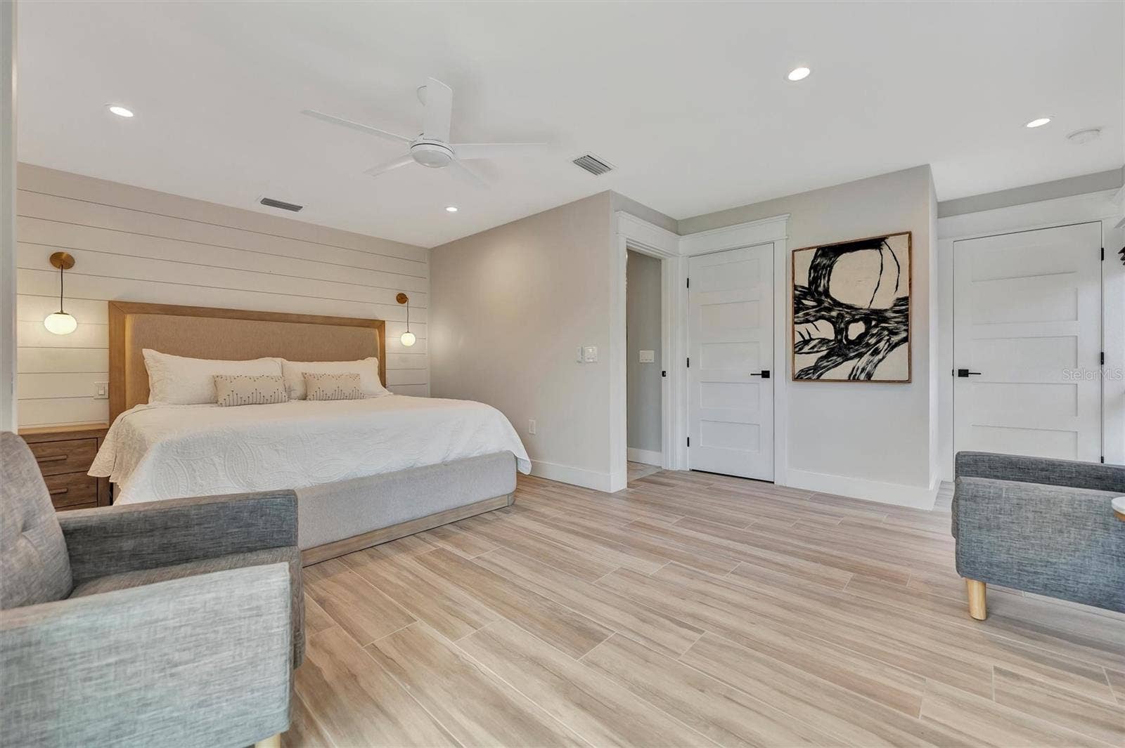 10115 KINGFISHER ROAD E, Bradenton, FL 34209 Primary suite with sliding glass doors, gorgeous views of the pool, turf area, and canal, plus an ensuite bathroom.