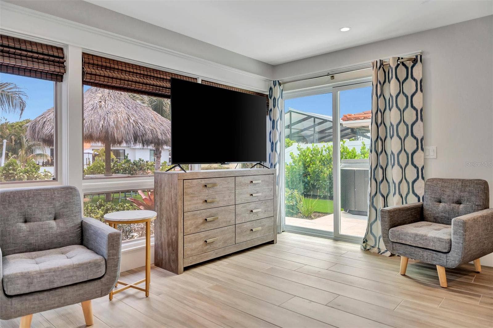 10115 KINGFISHER ROAD E, Bradenton, FL 34209 Primary suite with sliding glass doors, gorgeous views of the pool, turf area, and canal, plus an ensuite bathroom.