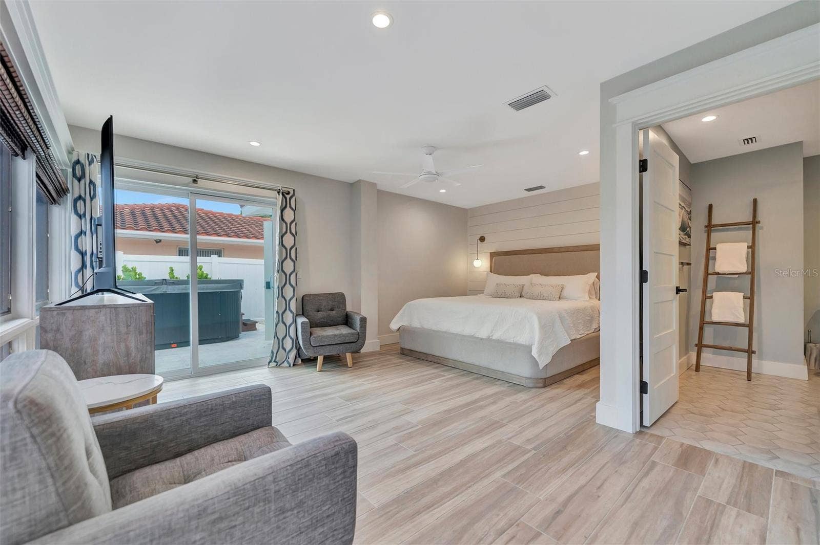 10115 KINGFISHER ROAD E, Bradenton, FL 34209 Primary suite with sliding glass doors, gorgeous views of the pool, turf area, and canal, plus an ensuite bathroom.