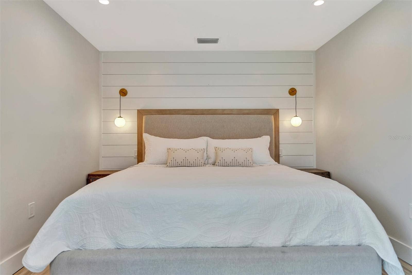 10115 KINGFISHER ROAD E, Bradenton, FL 34209 Primary suite with sliding glass doors, gorgeous views of the pool, turf area, and canal, plus an ensuite bathroom.