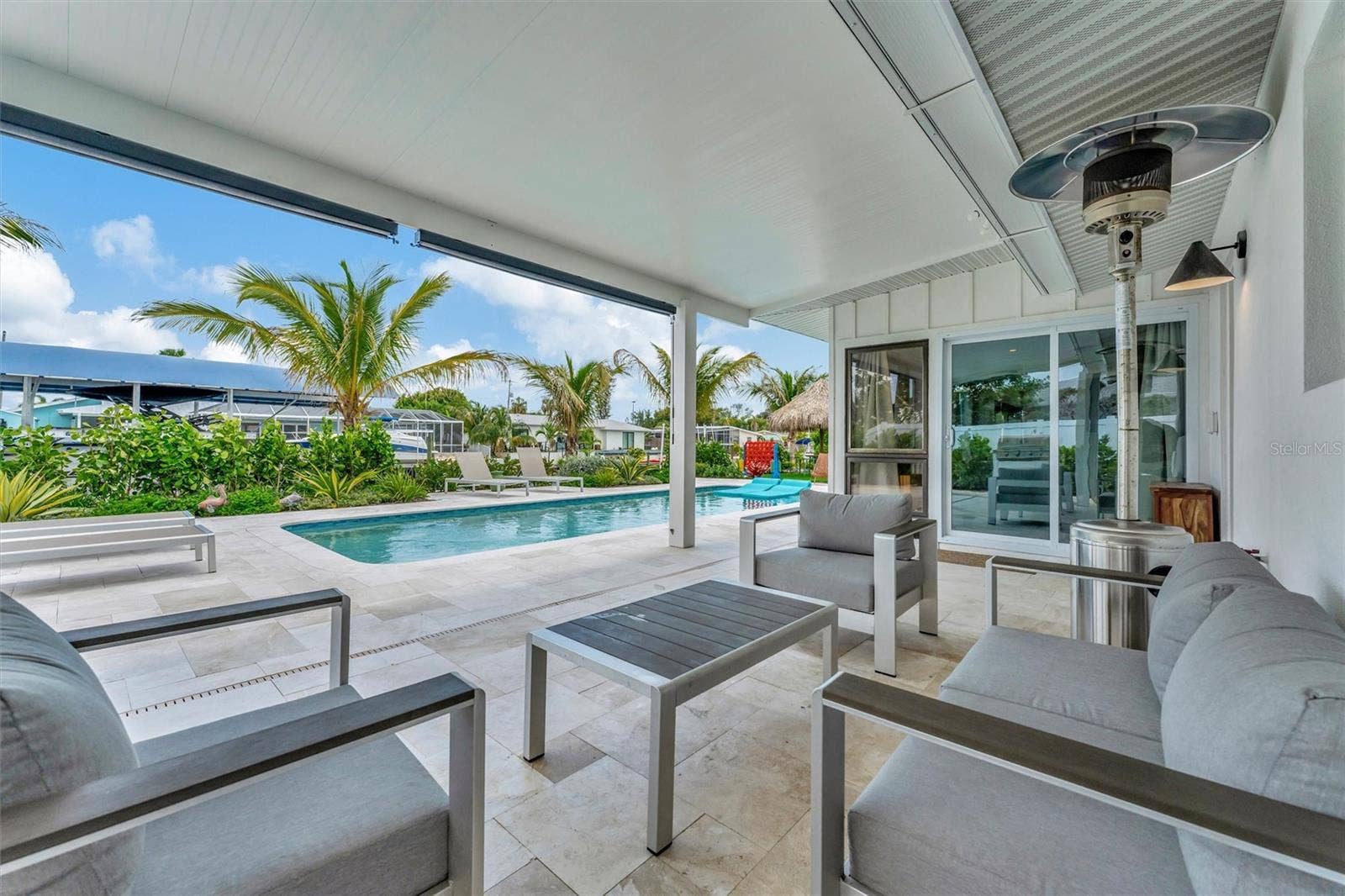 10115 KINGFISHER ROAD E, Bradenton, FL 34209 Heated saltwater pool, covered lanai, outdoor terraces, built-in propane grill, and tiki hut with turf games area.