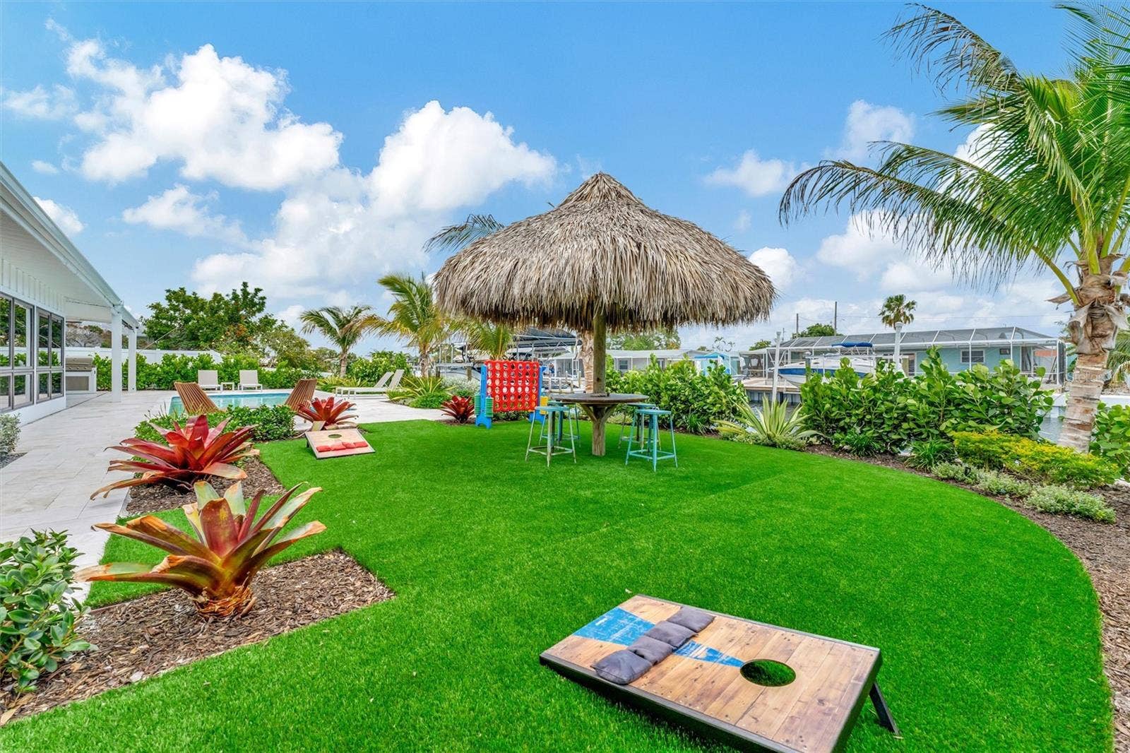 10115 KINGFISHER ROAD E, Bradenton, FL 34209 Covered lanai, multiple terraces, built-in propane grill, and tiki hut with turf games area.