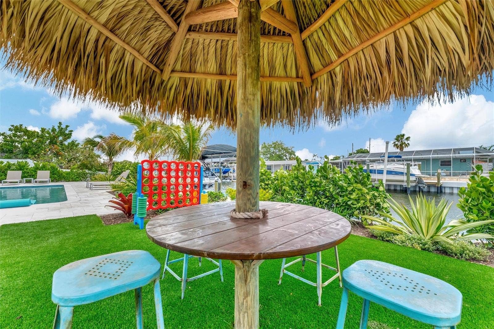 10115 KINGFISHER ROAD E, Bradenton, FL 34209 Covered lanai, multiple terraces, built-in propane grill, and tiki hut with turf games area.