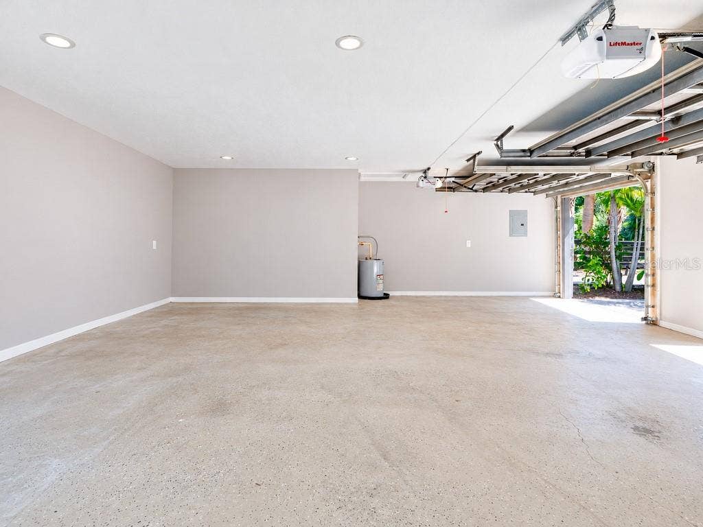 403 LONGBOW TRAIL, Osprey, FL 34229 Another view of the extended three-car garage, showcasing the impressive open floor area and additional space for storage, a workshop or car enthusiast needs.