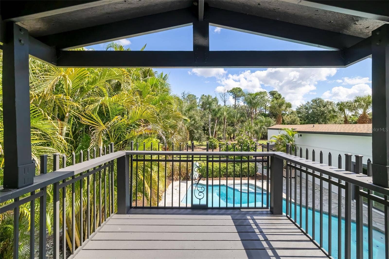 403 LONGBOW TRAIL, Osprey, FL 34229 Second-floor primary bathroom opens to a private covered balcony with relaxing views over the pool and surrounding tropical landscape.