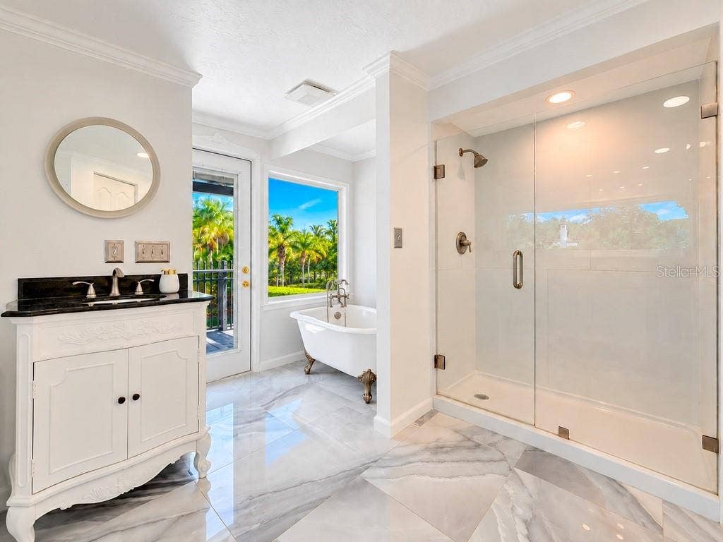 403 LONGBOW TRAIL, Osprey, FL 34229 VIRTUALLY RENOVATED Imagine the possibilities! Conceptual renovation of the upstairs primary bath featuring a freestanding tub, picture window and refreshed finishes. Improvements shown are not currently existing.