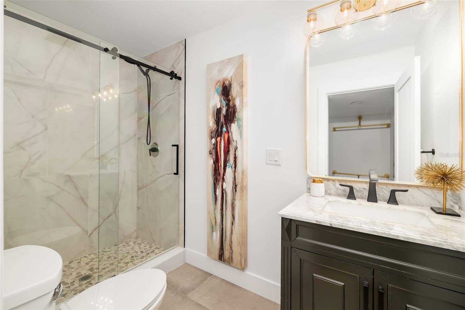 403 LONGBOW TRAIL, Osprey, FL 34229 Full bath serving the additional bedroom and living area, featuring a glass-enclosed shower and updated finishes.