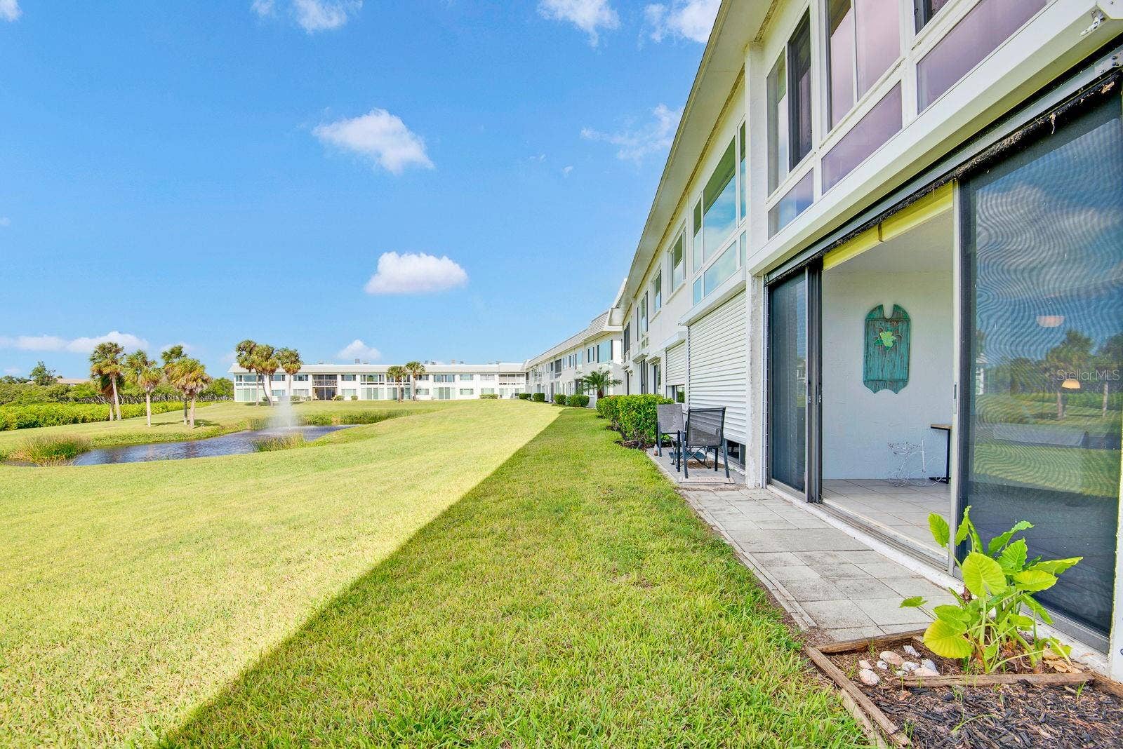 4745 INDEPENDENCE DRIVE, #4745, Bradenton, FL 34210 Outside back of condo lots of green grass and open area of water