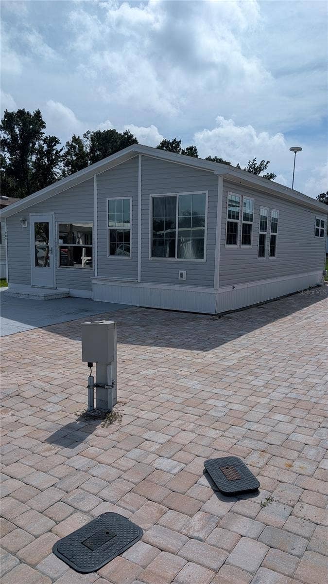 207 CITRUS RIDGE DRIVE, Davenport, FL 33837 EAST SIDE VIEW. NOTE PAVED AREA