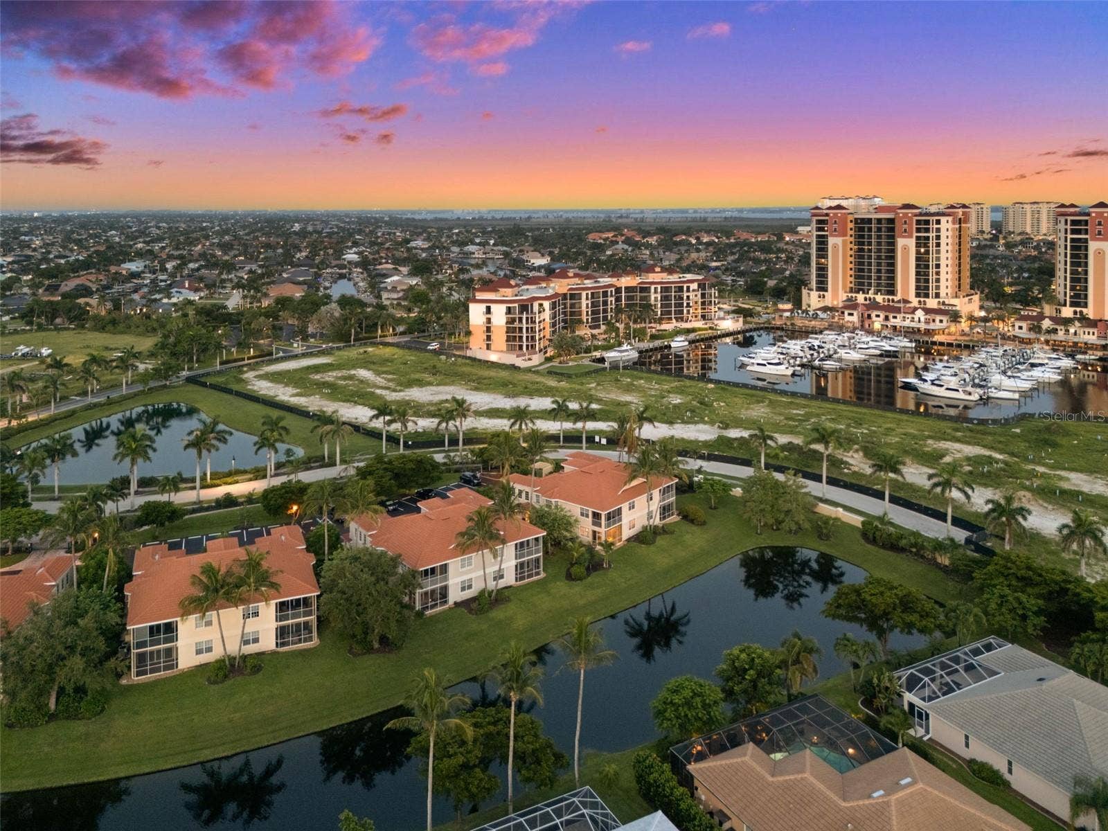 5626 CAPE HARBOUR DRIVE, #102, Cape Coral, FL 33914 Evening View of the Coach Houses with Cape Harbour in the background