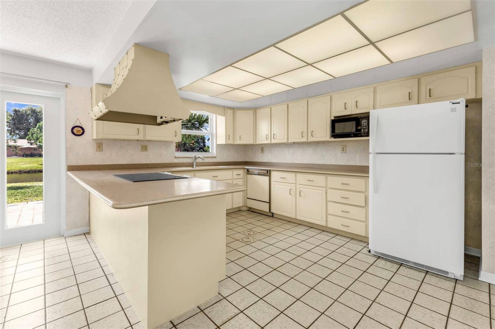 160 ANNAPOLIS LANE, Rotonda West, FL 33947 Kitchen with window views to your waterfront backyard and doorway to the back patio.