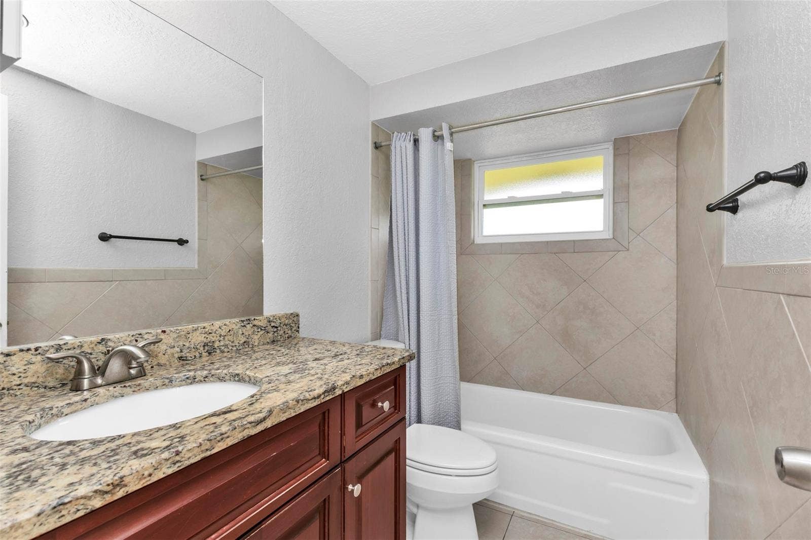 424 VANNELL STREET, Port Charlotte, FL 33954 Guest bathroom features single vanity with a shower/tub combo.