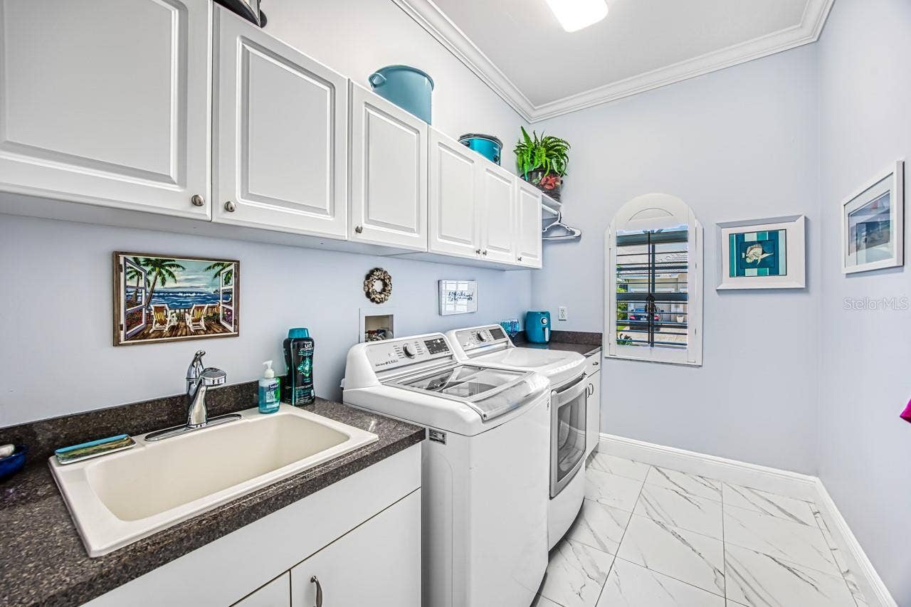 8625 SOUTHWIND BAY CIRCLE, Fort Myers, FL 33908 Laundry room with utility sink and storage cabinets