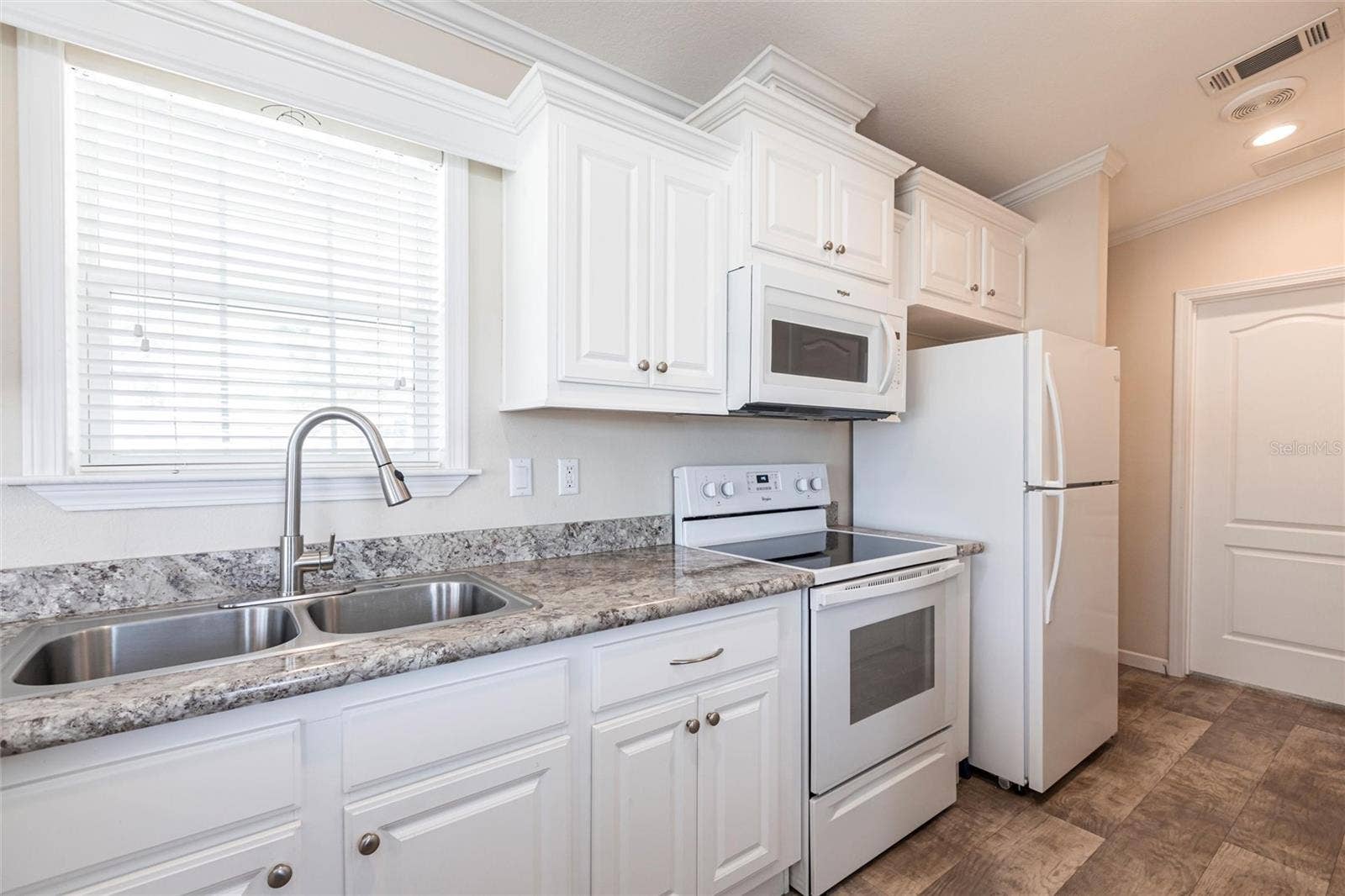 1329 TROUT, Punta Gorda, FL 33950 Kitchen with white cabinets and appliances