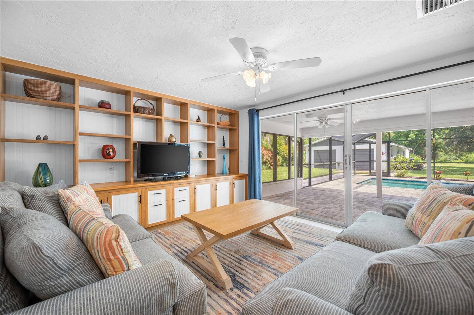 2111 HEASLEY ROAD, Englewood, FL 34223 Living room with built in shelving and sliders opening to the lanai