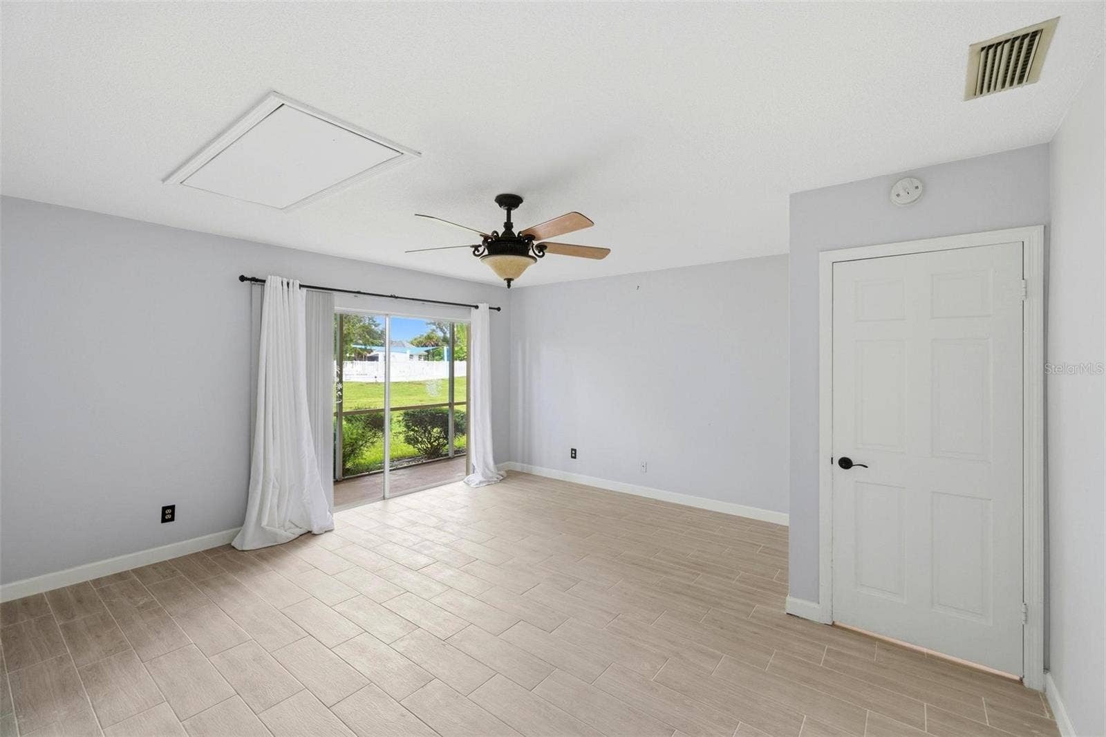 Large primary bedroom with patio doors onto lanai.