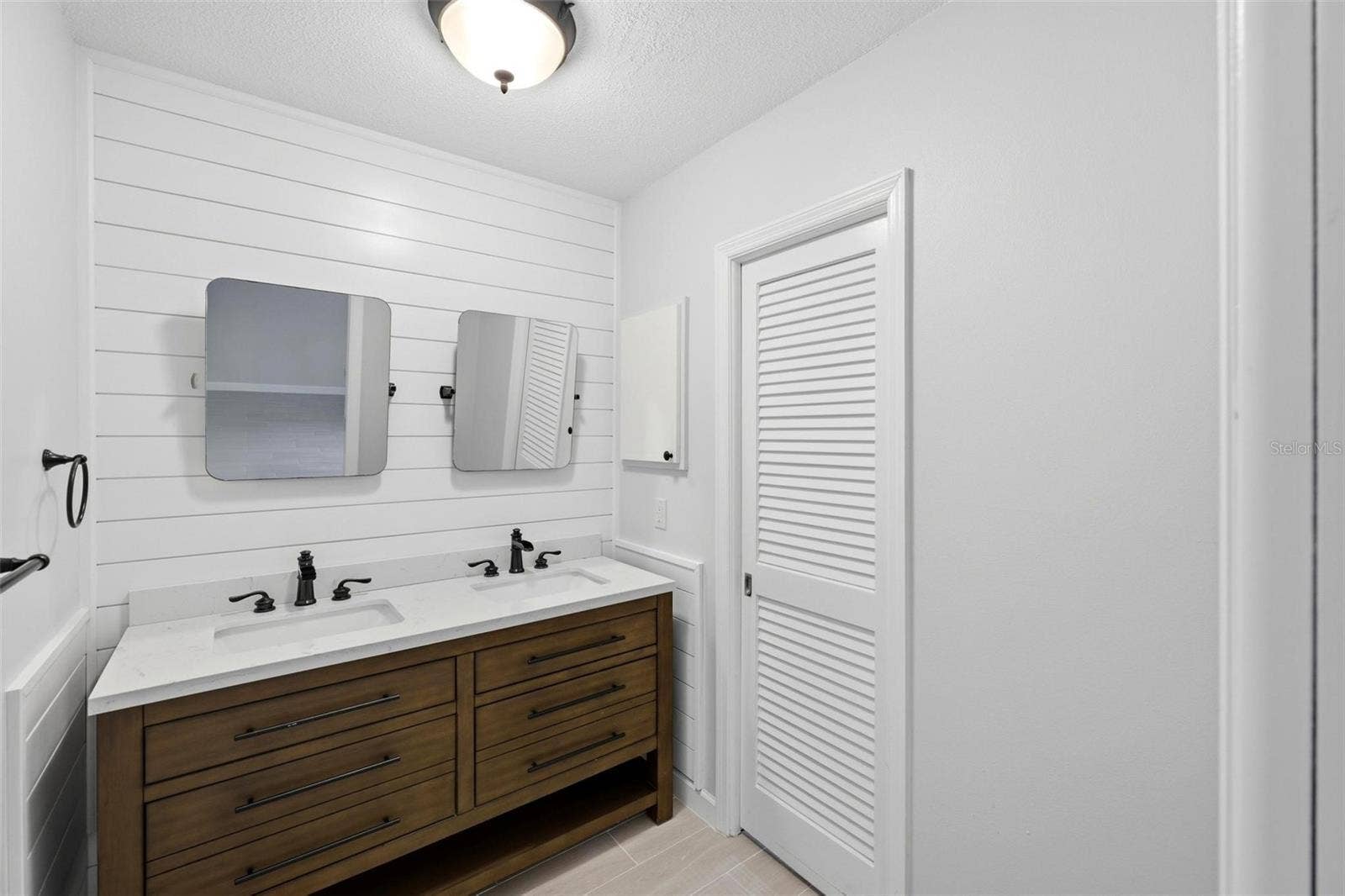 Primary ensuite bathroom with double sinks and mirrors.