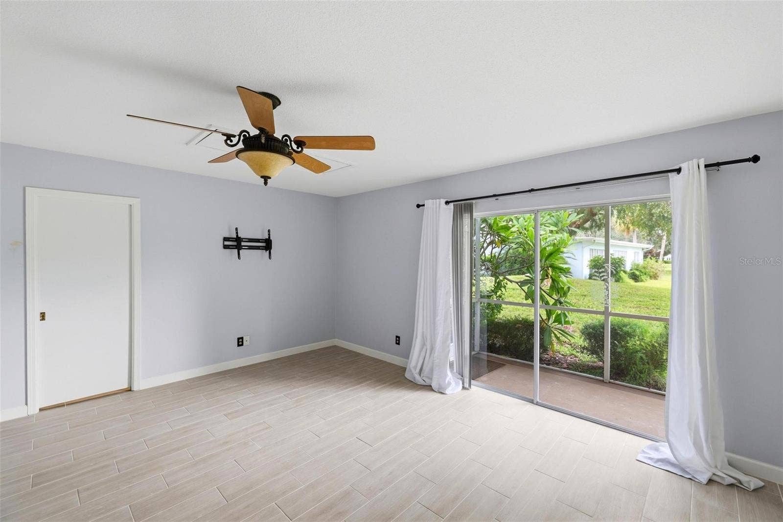 View from primary bedroom into lanai and rear yard.