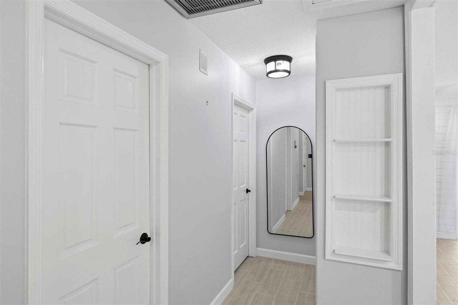 the hallway to the bedroom area.  Full length mirror for that double check before you leave the home.  A built in shelving unit for displaying favorite items.