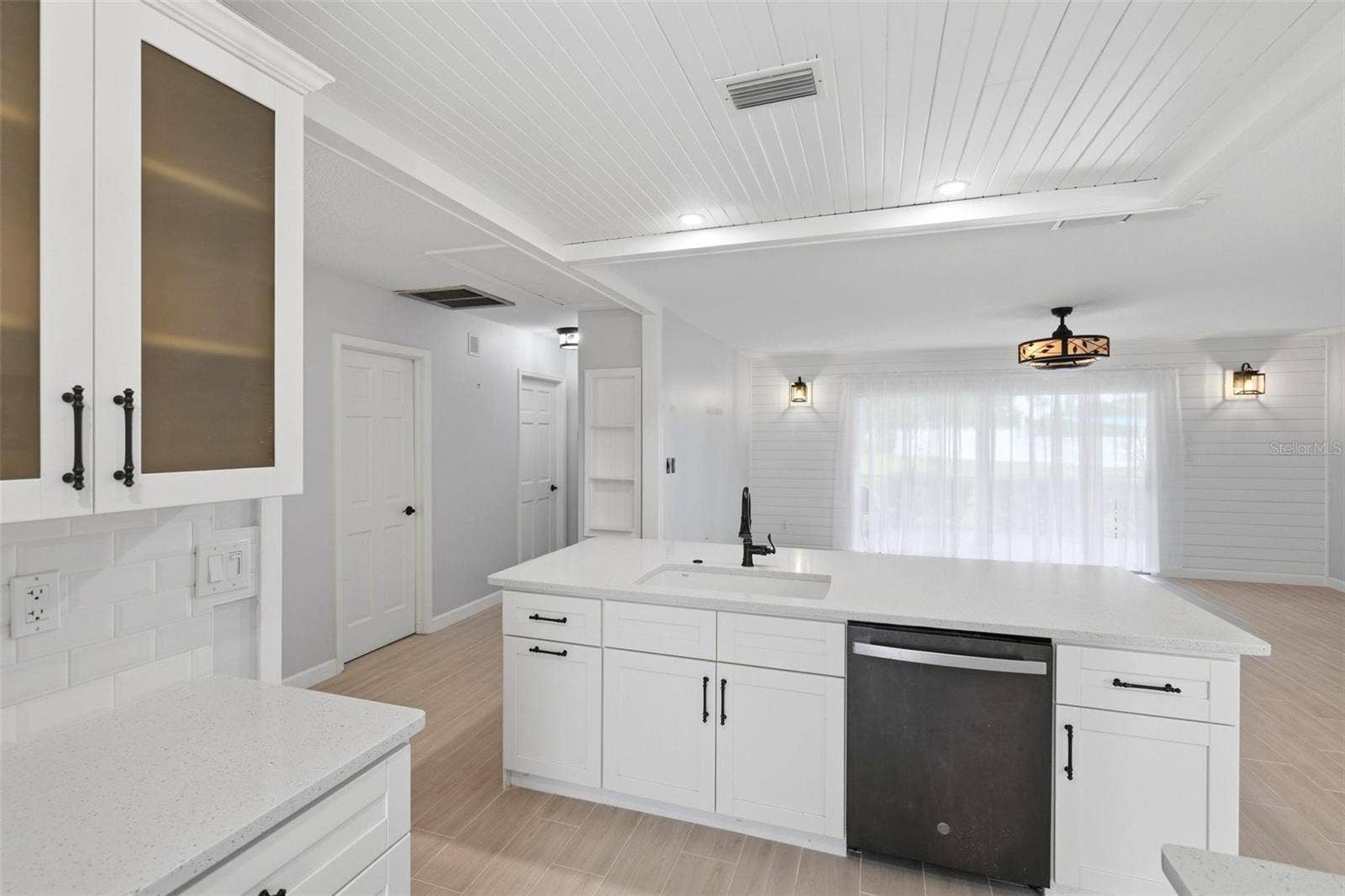 The opposite side of breakfast bar shows the sink, dishwasher and extra storage cabinetry.