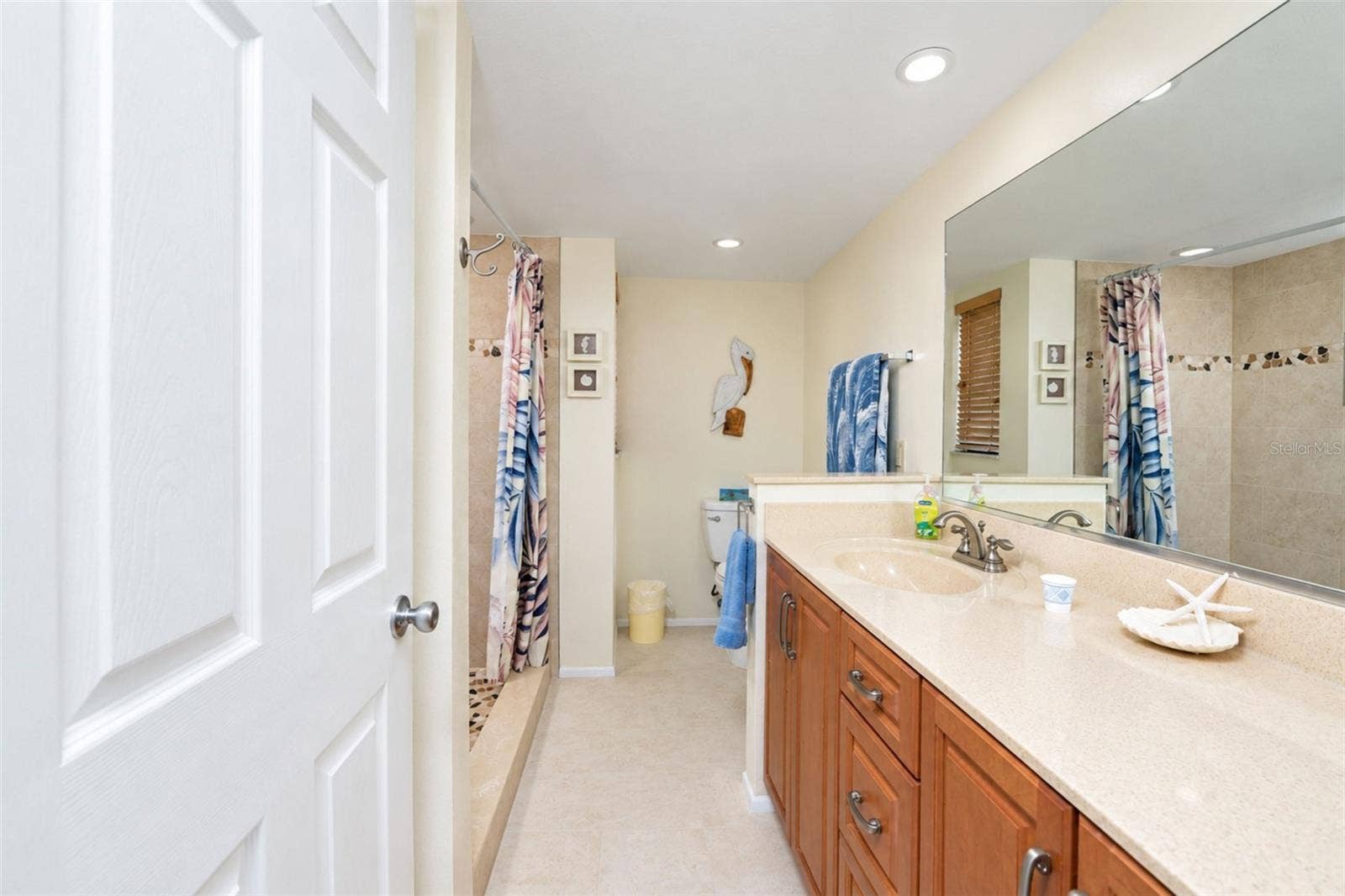 2950 N BEACH ROAD, #A321, Englewood, FL 34223 The primary bathroom has a solid surface countertop vanity with plenty of storage and tiled flooring.