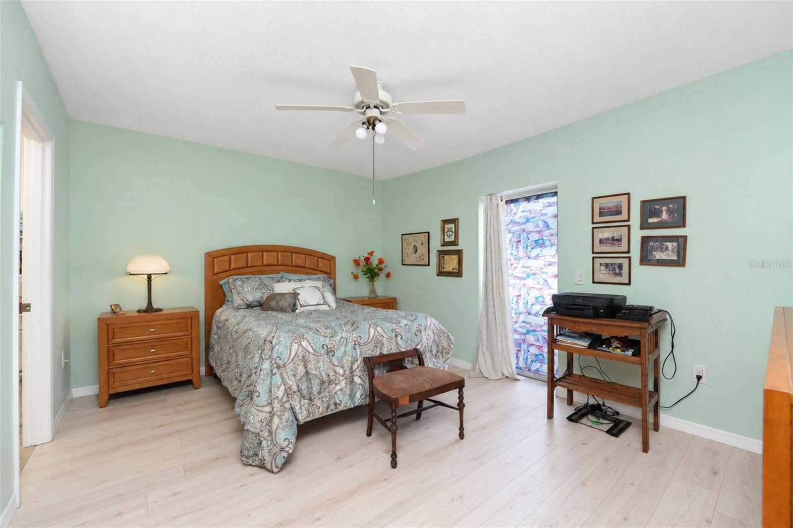 6468 HAMLET DRIVE, #B, Englewood, FL 34224 The primary bedroom features wood laminate flooring, a ceiling fan and sliding glass doors to the rear patio.