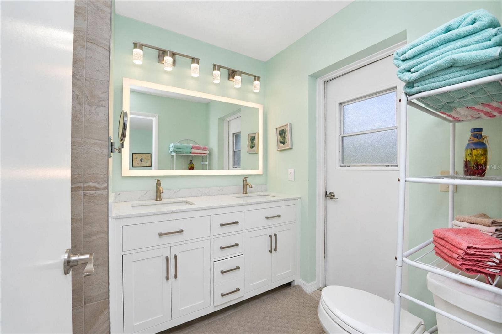 6468 HAMLET DRIVE, #B, Englewood, FL 34224 The updated ensuite bathroom features a new double sink vanity with solid-surface countertop, new faucets, touch control mirror, tiled flooring and direct access to the garage!