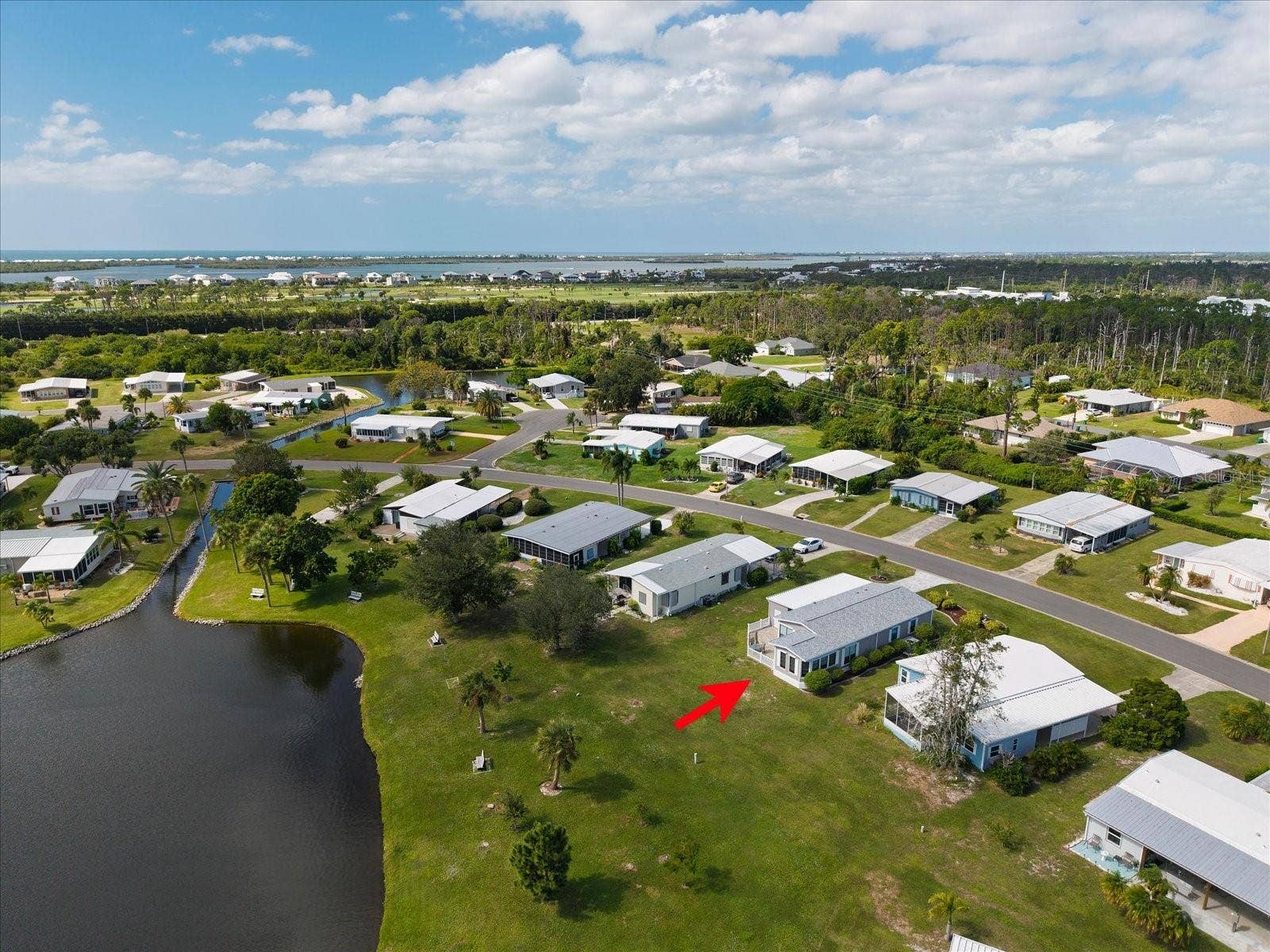 BACK AERIAL VIEW OF THE PROPERTY AND POND.