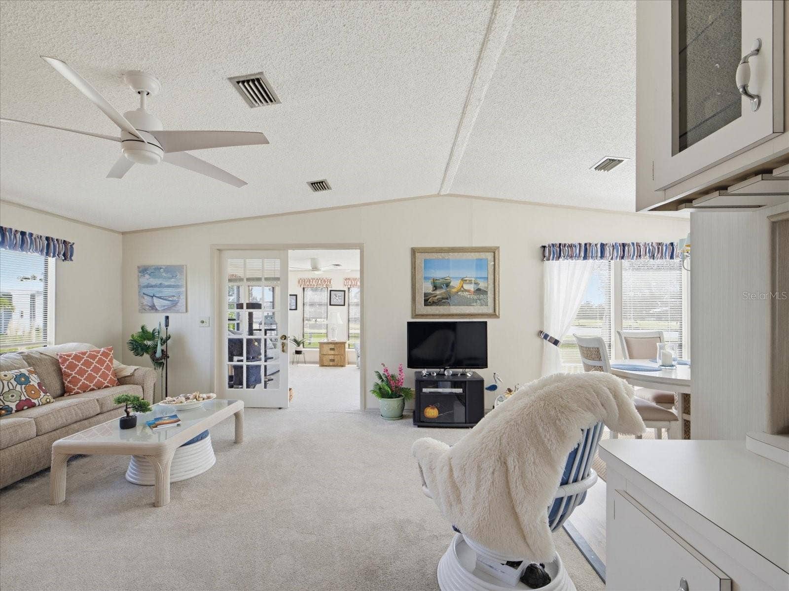 LIVING ROOM HAS A VAULTED CEILING. FRENCH DOORS LEAD TO THE FLORIDA ROOM.