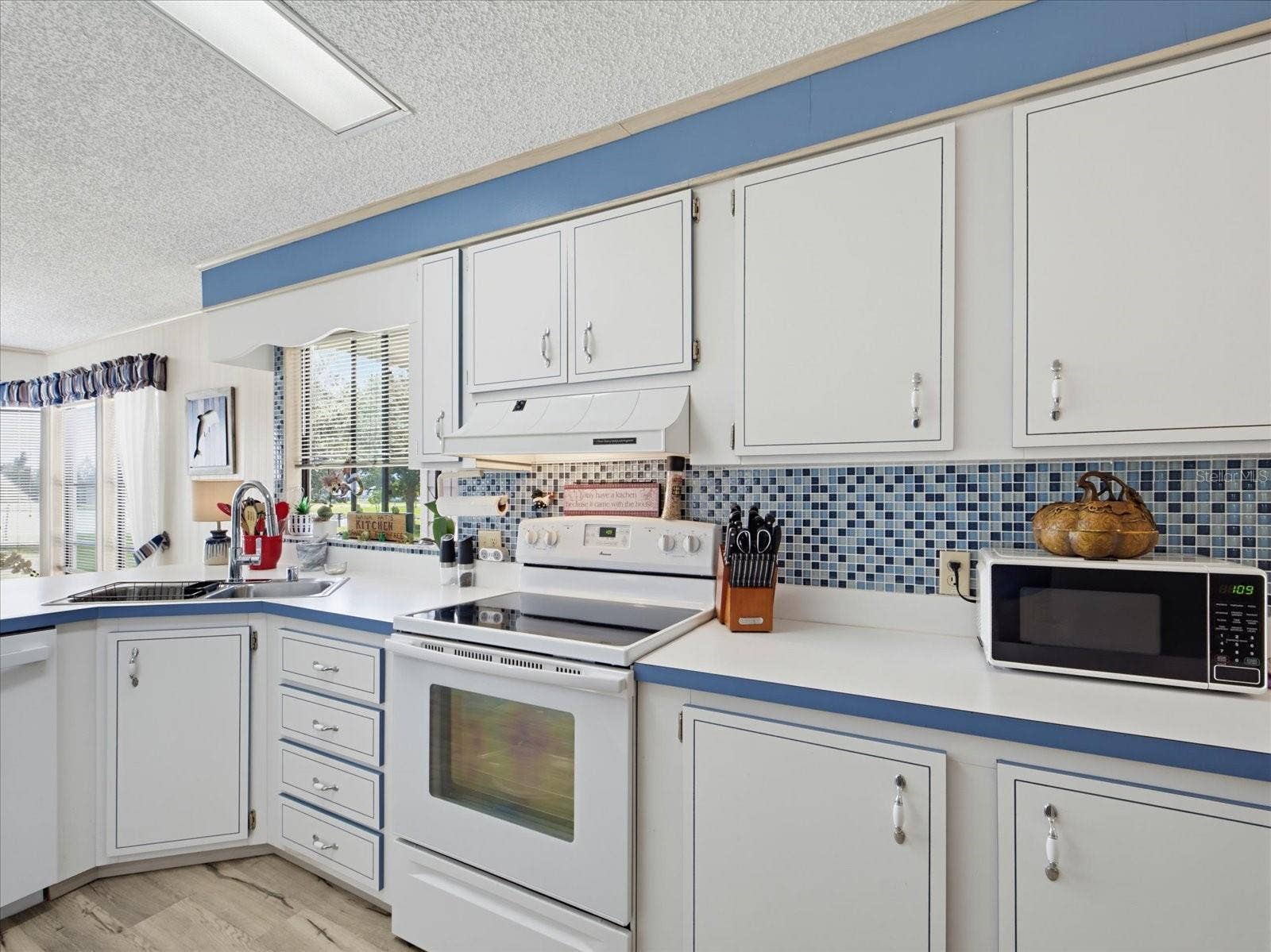 KITCHEN FEATURES A COASTAL BACKSPLASH.