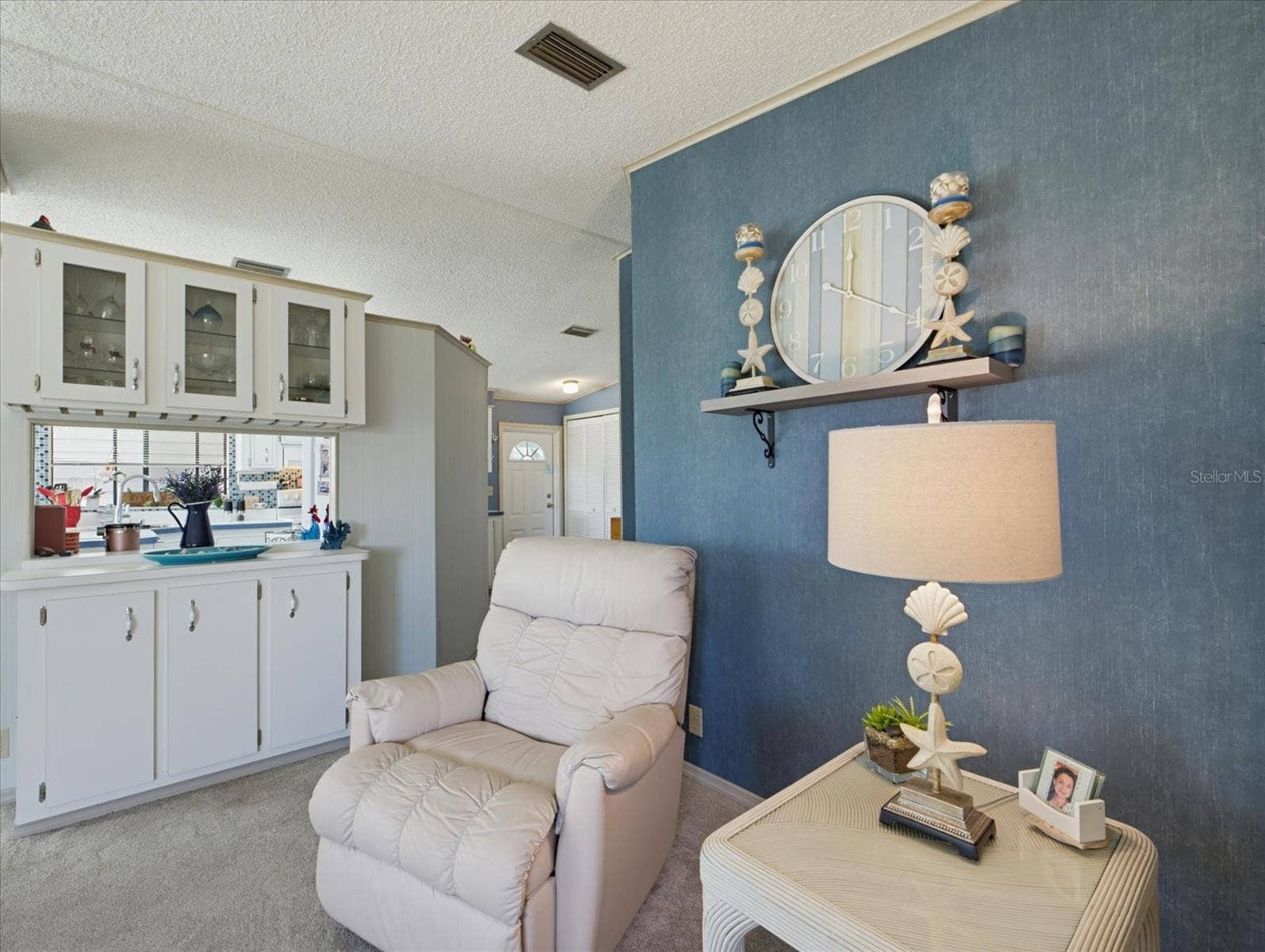 THERE IS DECORATIVE CABINTERY WITH A PASS-THROUGH WINDOW TO THE KITCHEN.