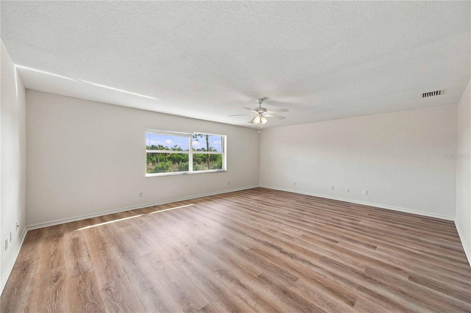 Great room with ceiling fan and vinyl plank flooring, enough room for pool table, bar, big screen tv and lounge chairs.