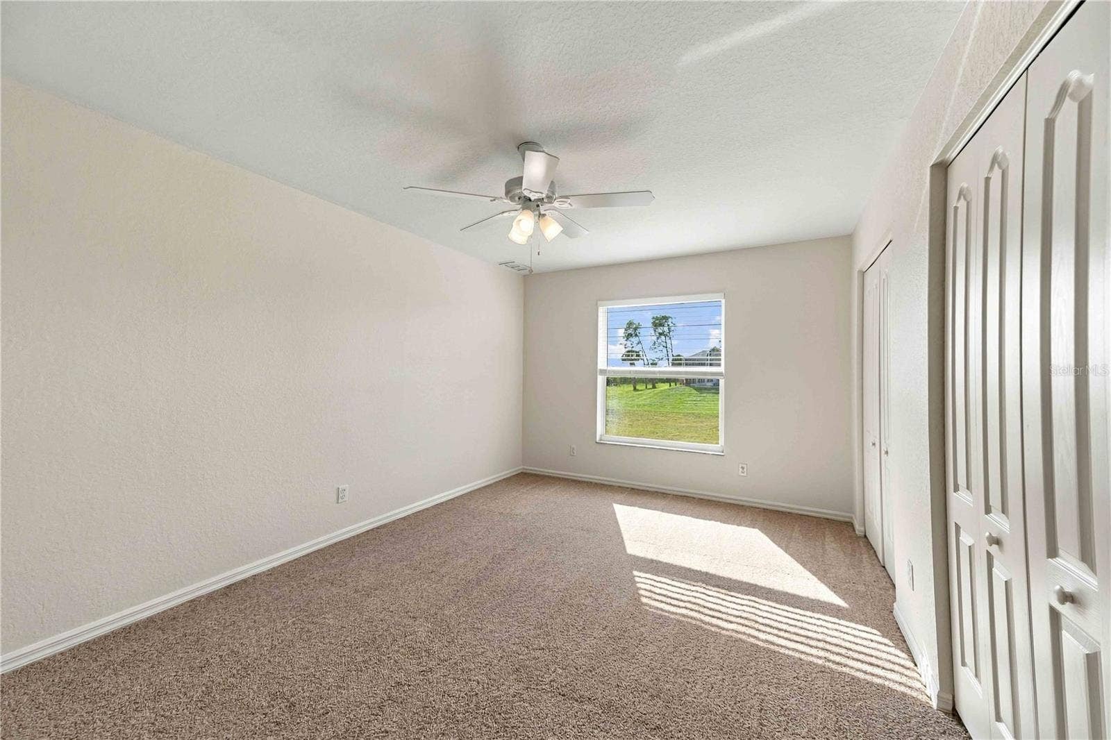 3rd bedroom with ceiling fan and natural light