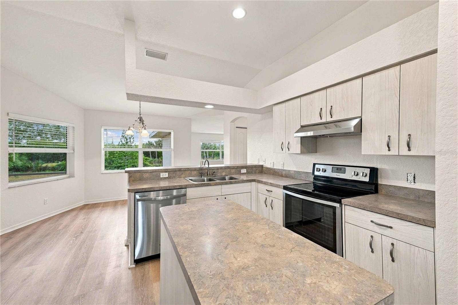 Kitchen island, granite-look counters, and bright windows