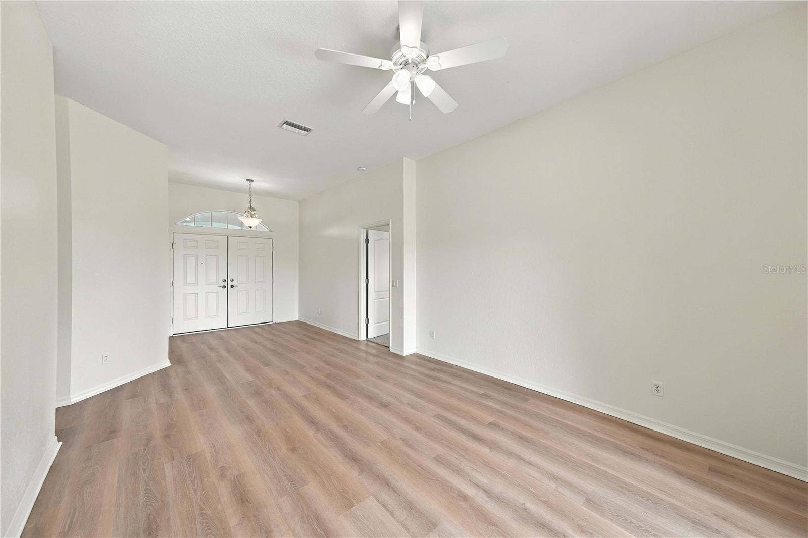 Open living area with vinyl plank flooring and ceiling fan