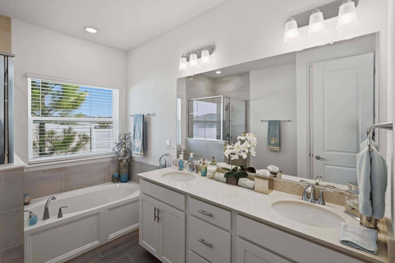 2110 RAGLAN CIRCLE, Ormond Beach, FL 32174 The ensuite primary bathroom has a large soaking tub and separate tiled showed. Featuring the wood plank style tile that is in the main living areas.