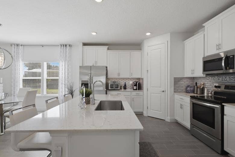 2110 RAGLAN CIRCLE, Ormond Beach, FL 32174 Check out the quartz countertops and high-end wood grain plank style tile flooring that runs throughout the living areas in this home.
