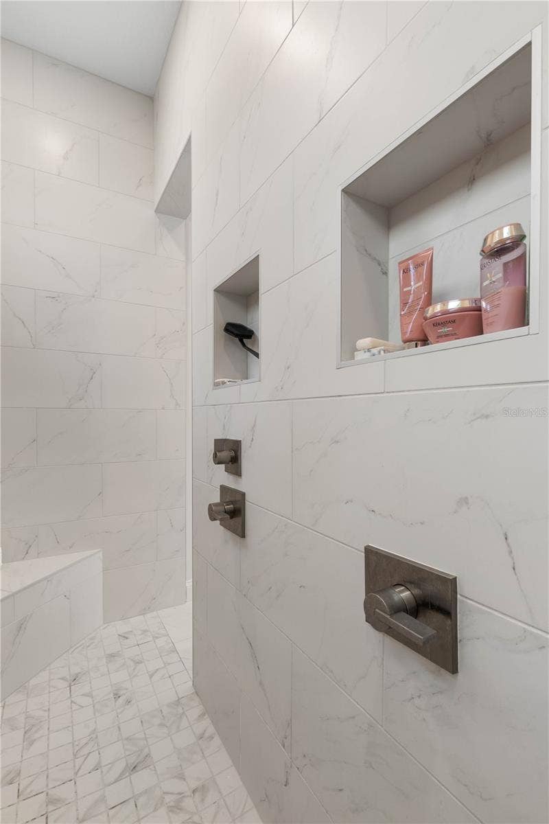 Convenient built-in storage shelves in the walk-through shower