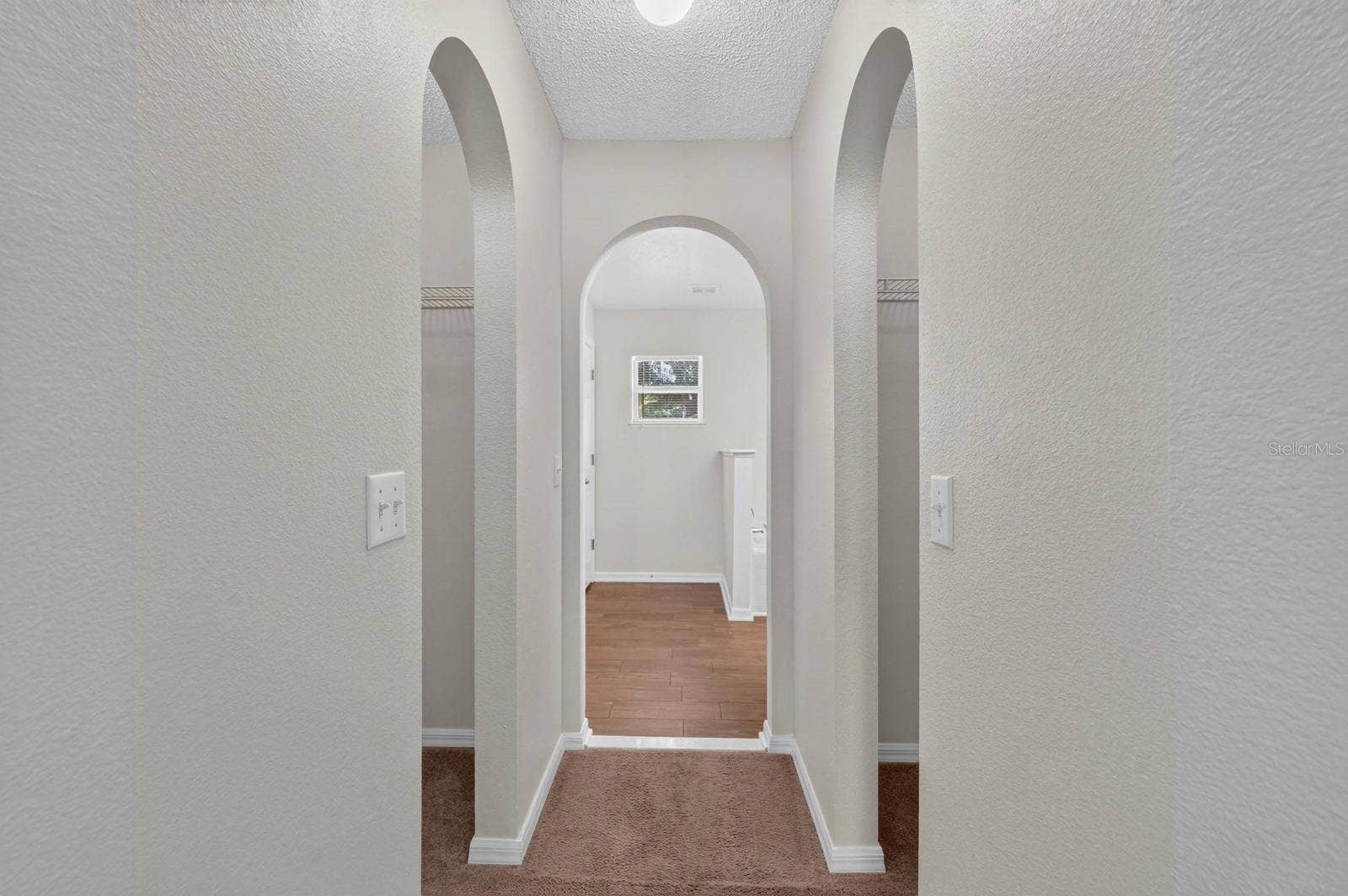 99 PICKERING DRIVE, Palm Coast, FL 32164 primary bedroom looking towards ensuite bath with his and her closets on either side before the bathroom