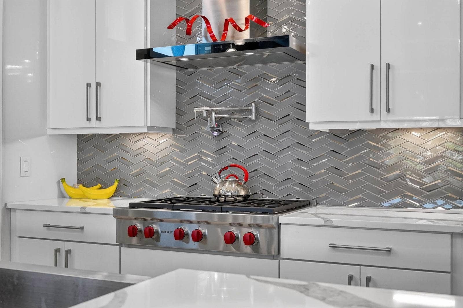 304 YACHT HARBOR DRIVE, Palm Coast, FL 32137 Wolf gas range, pot filler, custom cabinetry and a striking herringbone backsplash pair professional-grade function with polished design.