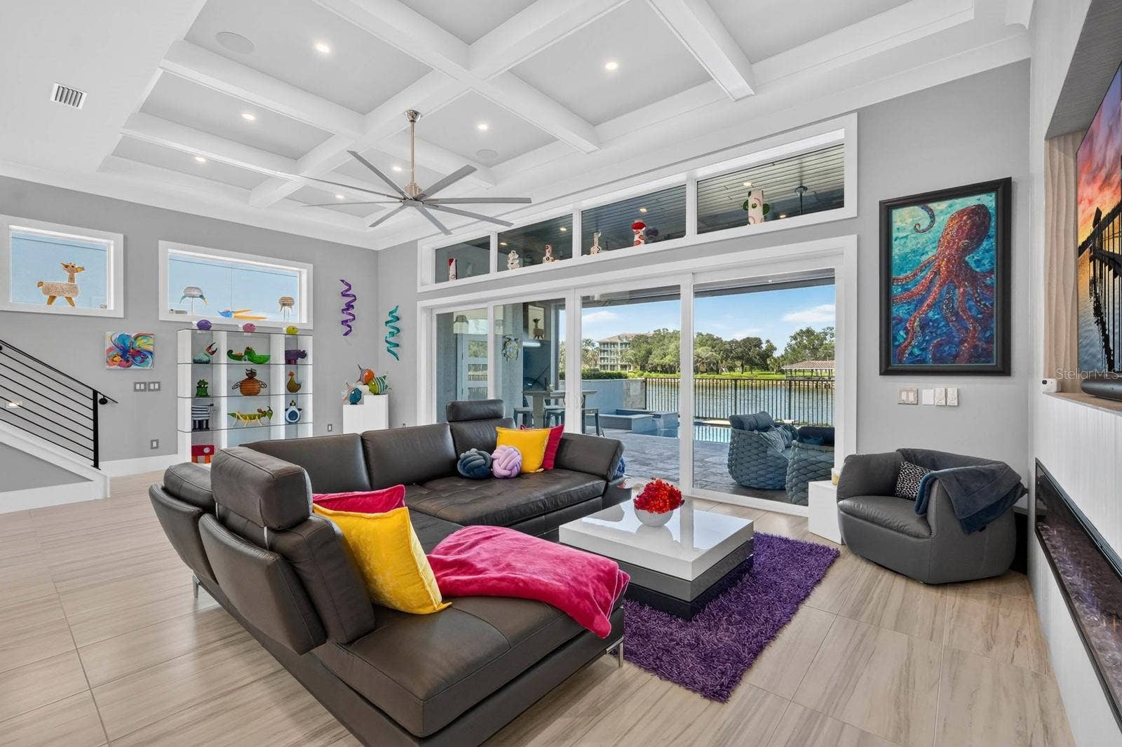 304 YACHT HARBOR DRIVE, Palm Coast, FL 32137 Main-level gathering space with a sleek electric fireplace, integrated entertainment wall and direct connection to the covered outdoor living, pool and Intracoastal.