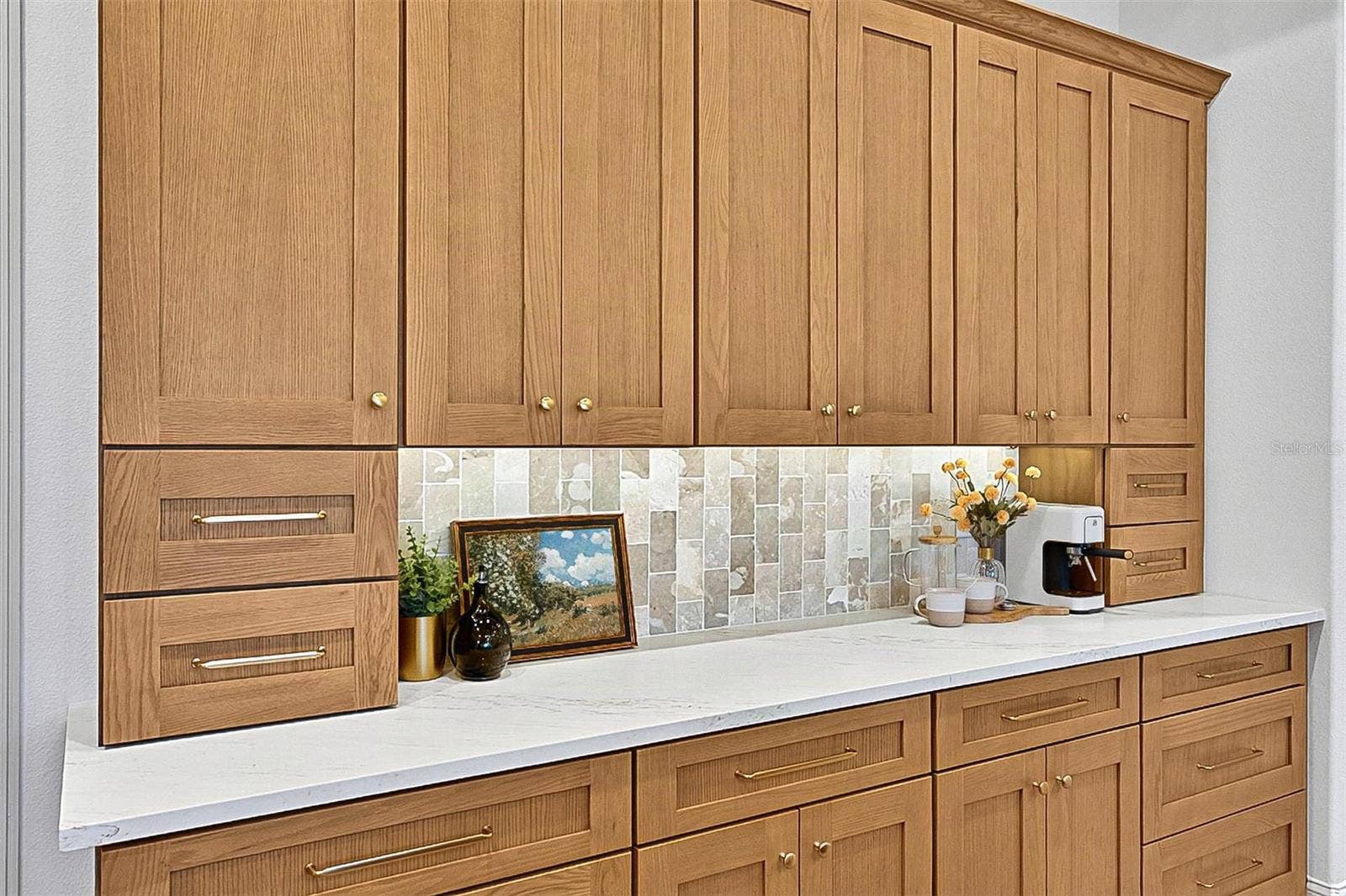 17 GRANDVIEW DRIVE, Palm Coast, FL 32137 Full wall of Custom Wood soft close cabinets with under-mount lighting against the stunning tile and quartz countertops