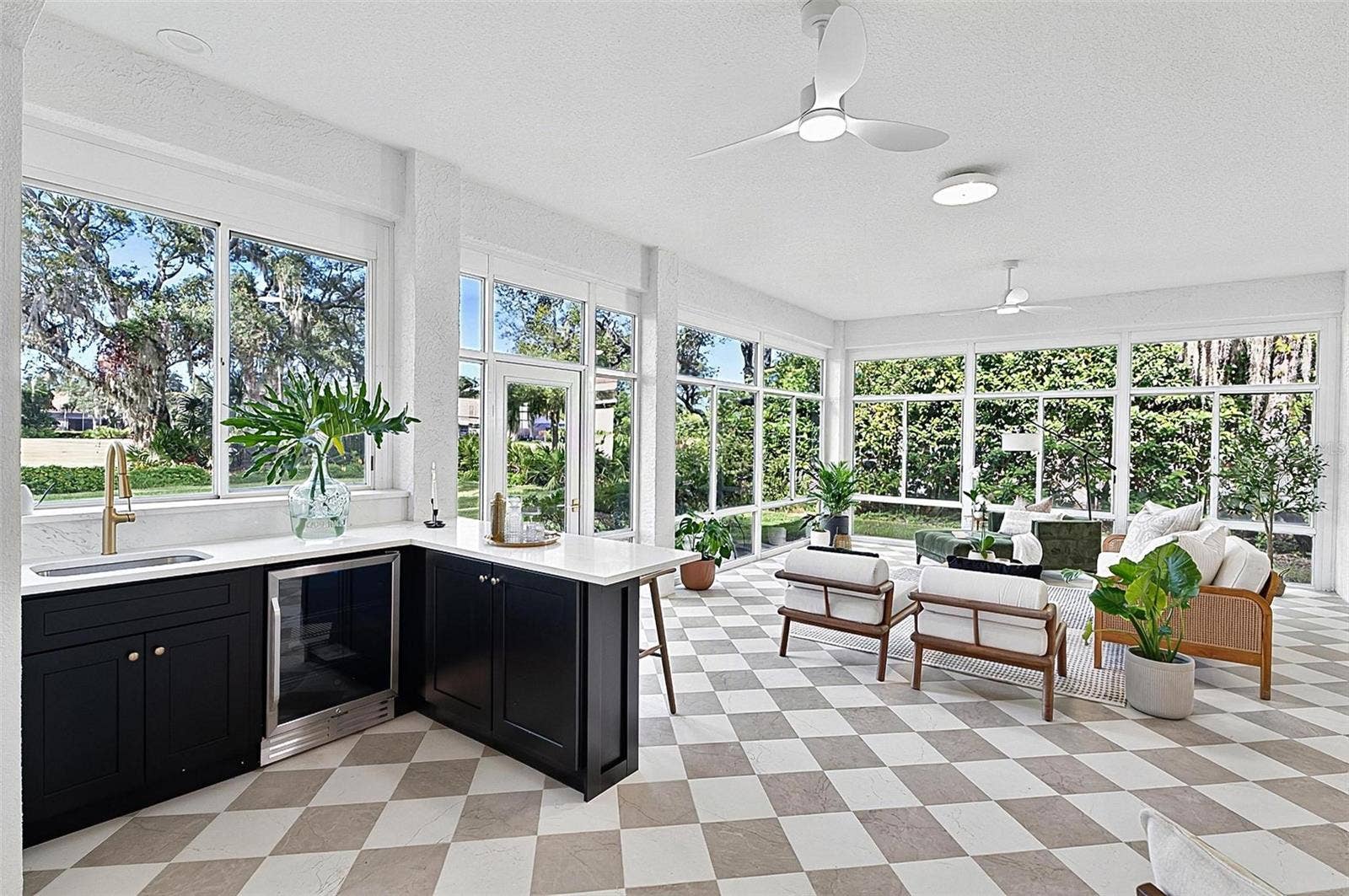 17 GRANDVIEW DRIVE, Palm Coast, FL 32137 Custom wet bar with beverage refrigerator and quartz countertop in the solarium with wall to wall enclosed screen window for a view of nature at its best. Room is aired