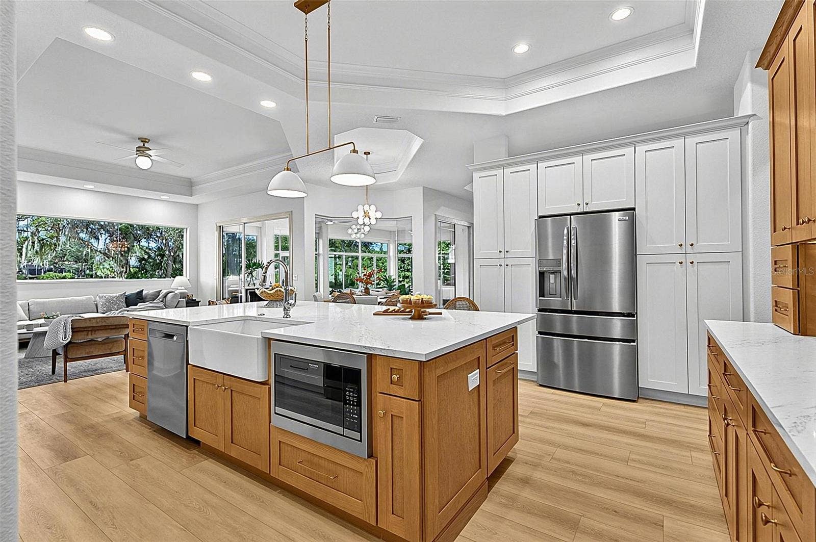 17 GRANDVIEW DRIVE, Palm Coast, FL 32137 Kitchen Island with farm sink, dishwasher and microwave showing refrigerator with wall of pantry cabinets and family room