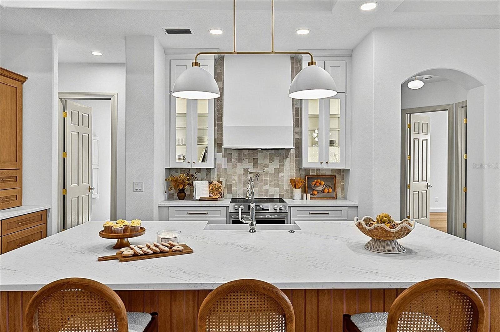 17 GRANDVIEW DRIVE, Palm Coast, FL 32137 Elegant Centerpiece Kitchen Island with crafted wall of tile and lighted window cabinets