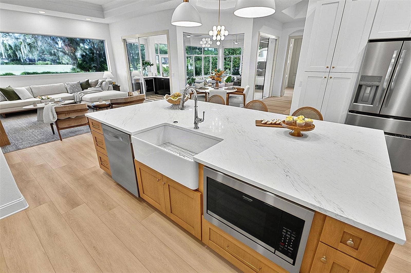 17 GRANDVIEW DRIVE, Palm Coast, FL 32137 Kitchen Island with farm sink, dishwasher and microwave showing refrigerator with wall of pantry cabinets and family room