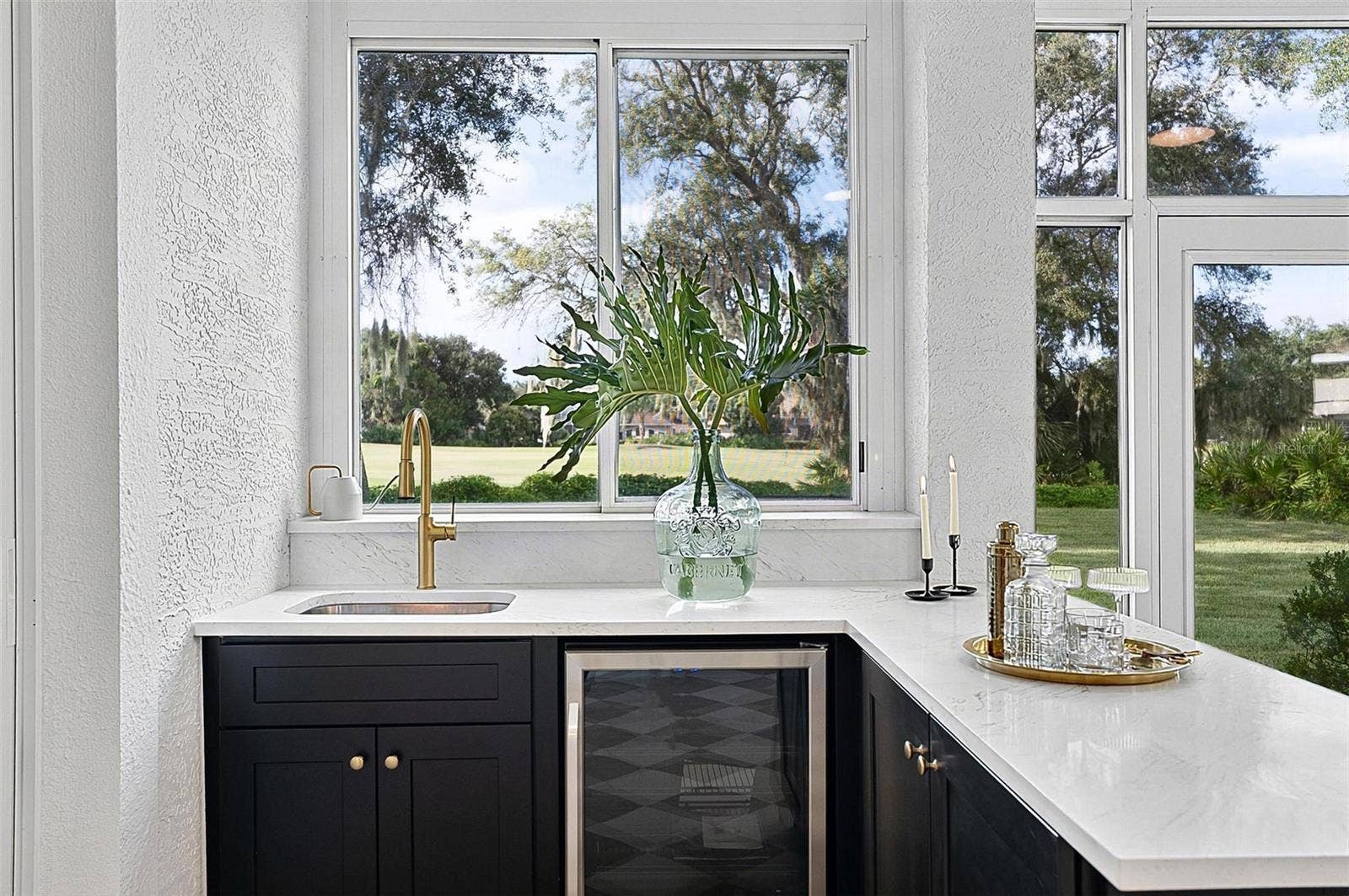 17 GRANDVIEW DRIVE, Palm Coast, FL 32137 Custom wet bar with beverage refrigerator and quartz countertop in the solarium