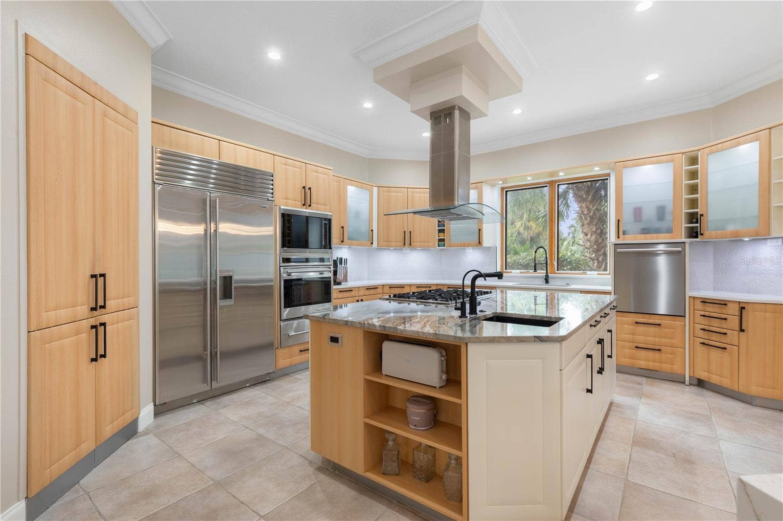 A chefs dream kitchen where sleek custom cabinetry, gleaming stone surfaces, and professional-grade appliances come together in a symphony of modern elegance and effortless sophistication.
