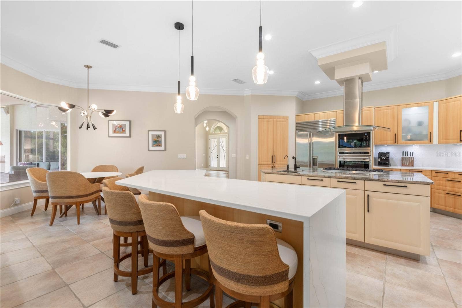 The showpiece kitchen invites everyone to gather around its dramatic waterfall island, while European cabinetry and an impressive suite of gourmet appliances make every meal feel worthy of the setting.