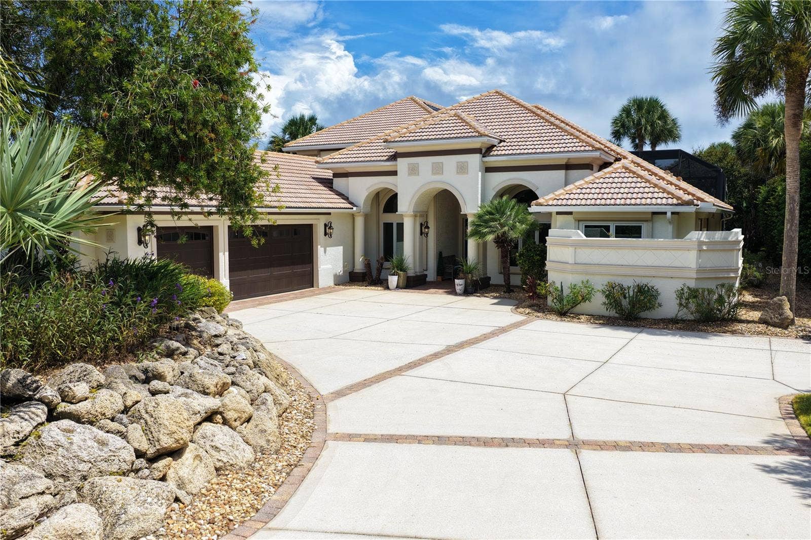 A stately arched entry and graceful architectural lines create a memorable first impression, hinting at the beautifully reimagined residence and waterfront lifestyle that await inside.